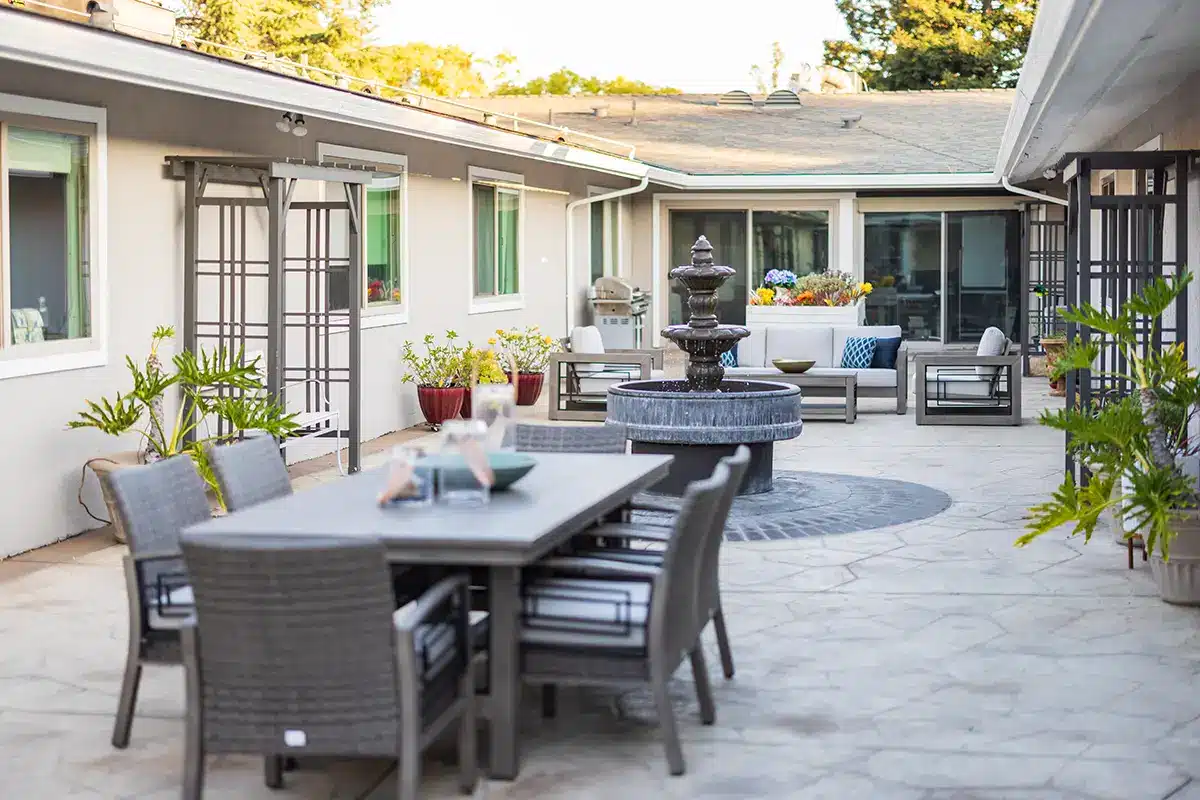 A courtyard with a table and fountain at Sunnyvale Post Acute