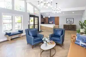 A common room with chairs and large windows at Sunnyvale Post Acute