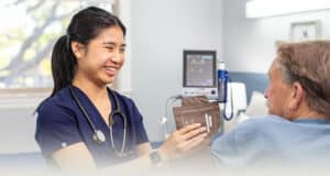 A nurse helping an elderly woman at Sunnyvale Post Acute