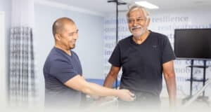 A physical therapist helping a man walk at Sunnyvale Post Acute